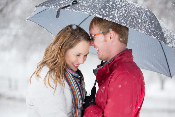Under a snowy umbrella having a beautiful moment together in the midlands